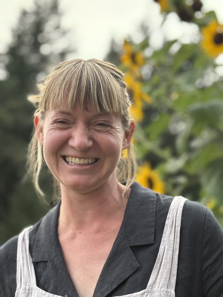 Winemaker Julia Bailey smiling in front of sunflowers