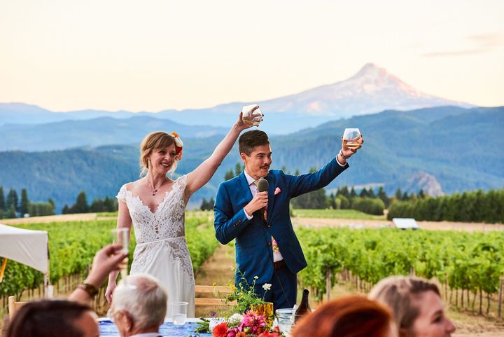 A celebration toast in the vineyard with Mt. Hood behind